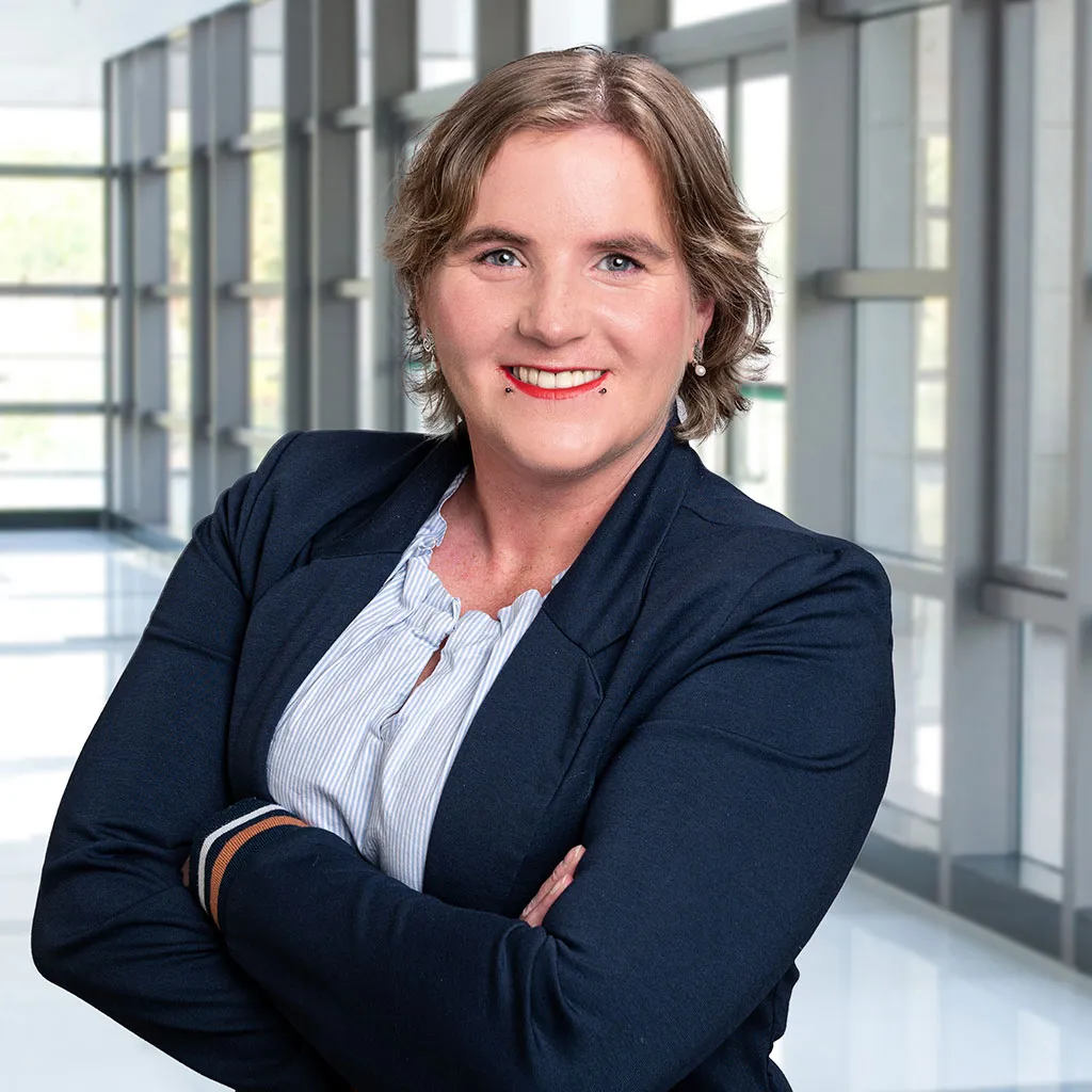 Business-Porträt einer Frau in Schleswig vor einer unscharfen Glasfassade, Teil einer Personal-Branding-Serie, mit natürlichem Licht und professioneller Ausstrahlung